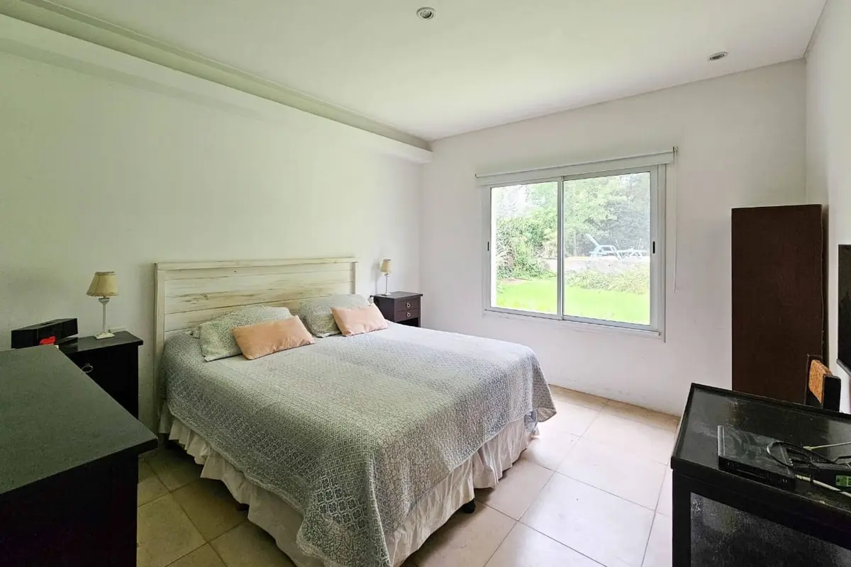 Dormitorio moderno con cama king, luz cálida y ventana grande — proyecto San Matías, por GeN Arquitectura, en Ingeniero Maschwitz